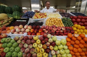 A vendor sells vegetables and fruits at the city market in St.Petersburg